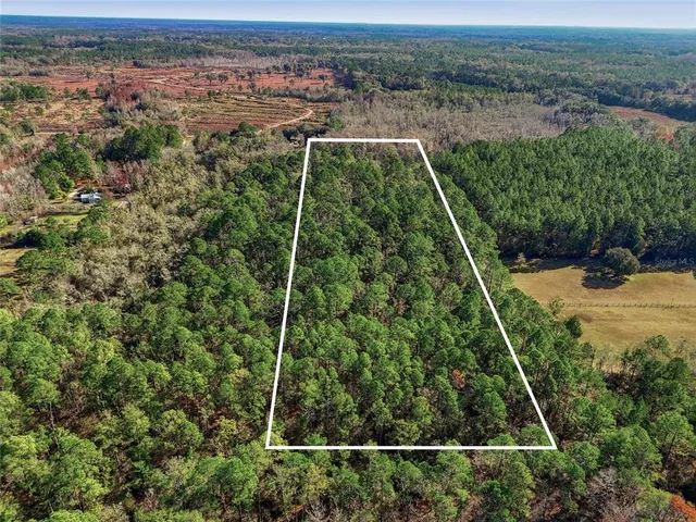 an aerial view of a houses with a yard and lake view
