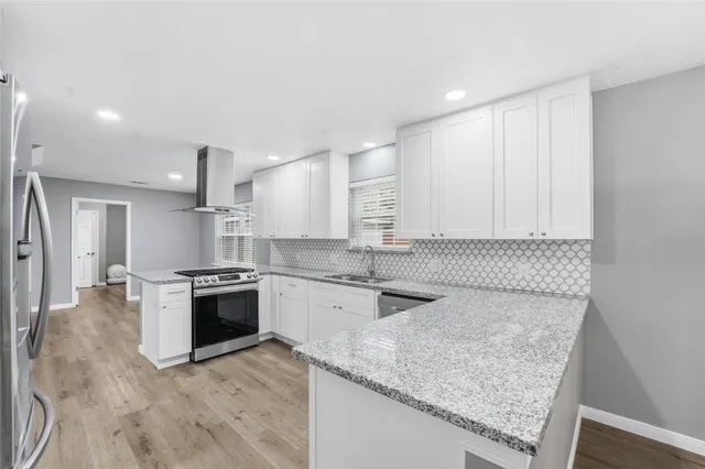 a kitchen with stainless steel appliances granite countertop a sink stove and cabinets
