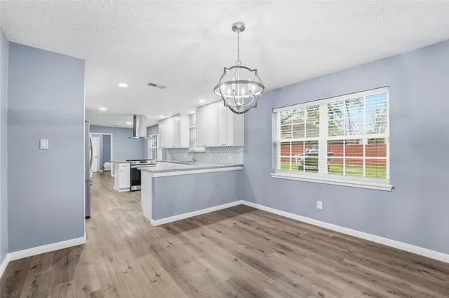 a view of a kitchen with wooden floor and stainless steel appliances