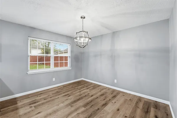 a view of empty room with wooden floor and windows
