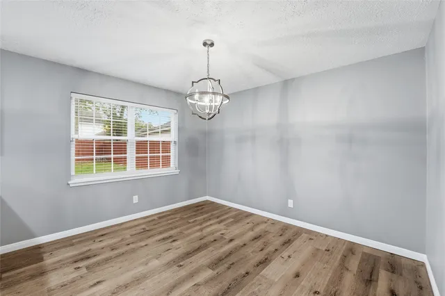a view of empty room with wooden floor and windows
