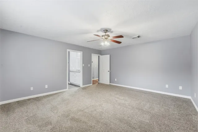 a view of an empty room with a chandelier fan
