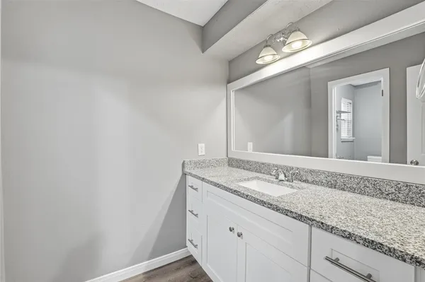 a bathroom with a granite countertop sink and a mirror