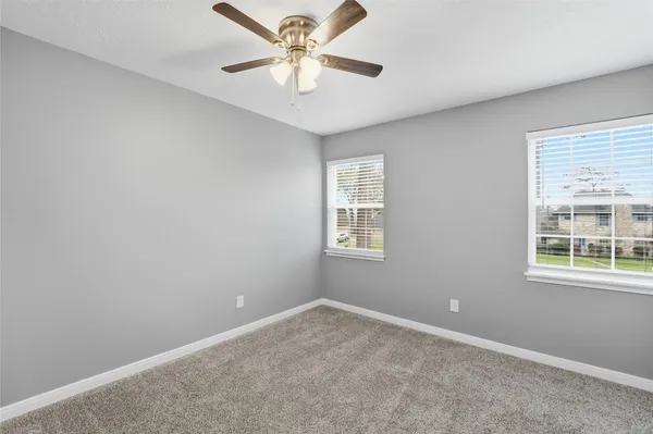 an empty room with a window and a fan
