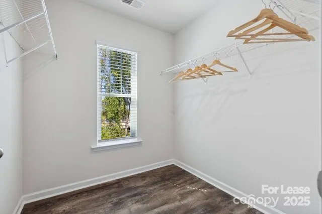 an empty room with a window and ceiling fan
