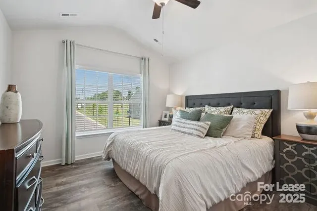 a bedroom with a bed a dresser and a window