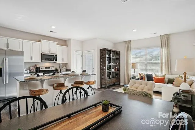 a kitchen with sink refrigerator dining table and chairs