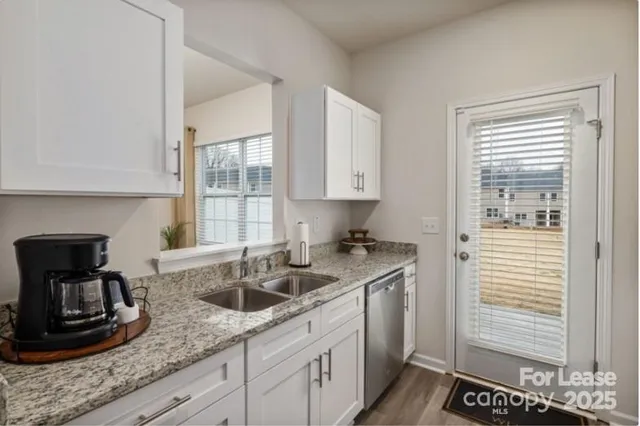 a kitchen with stainless steel appliances granite countertop a sink stove and cabinets