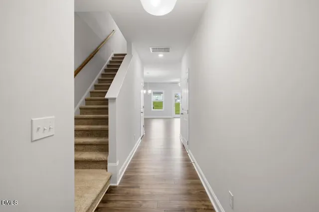 a view of a hallway with wooden floor and entryway