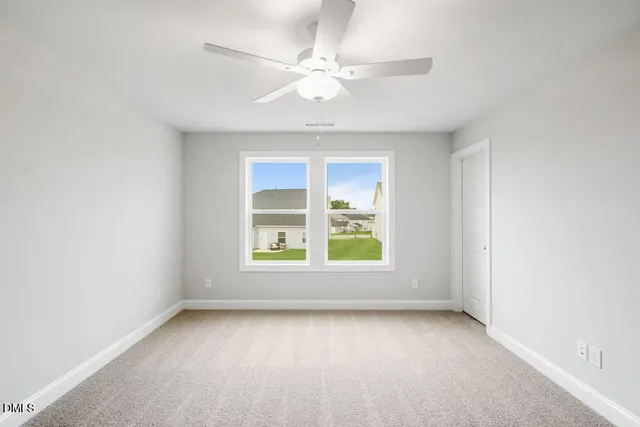 an empty room with a window and a fan