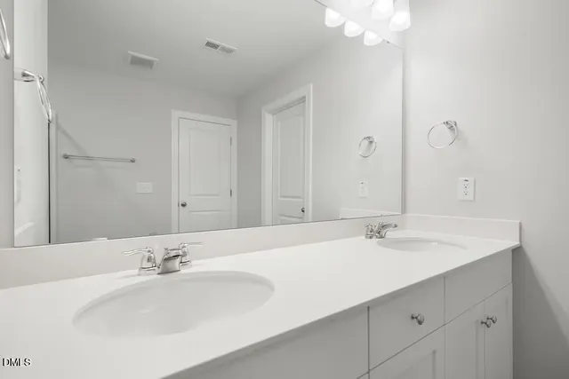 a bathroom with double vanity sinks and a mirror