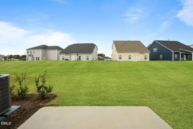 a view of a big house with a big yard and large tree