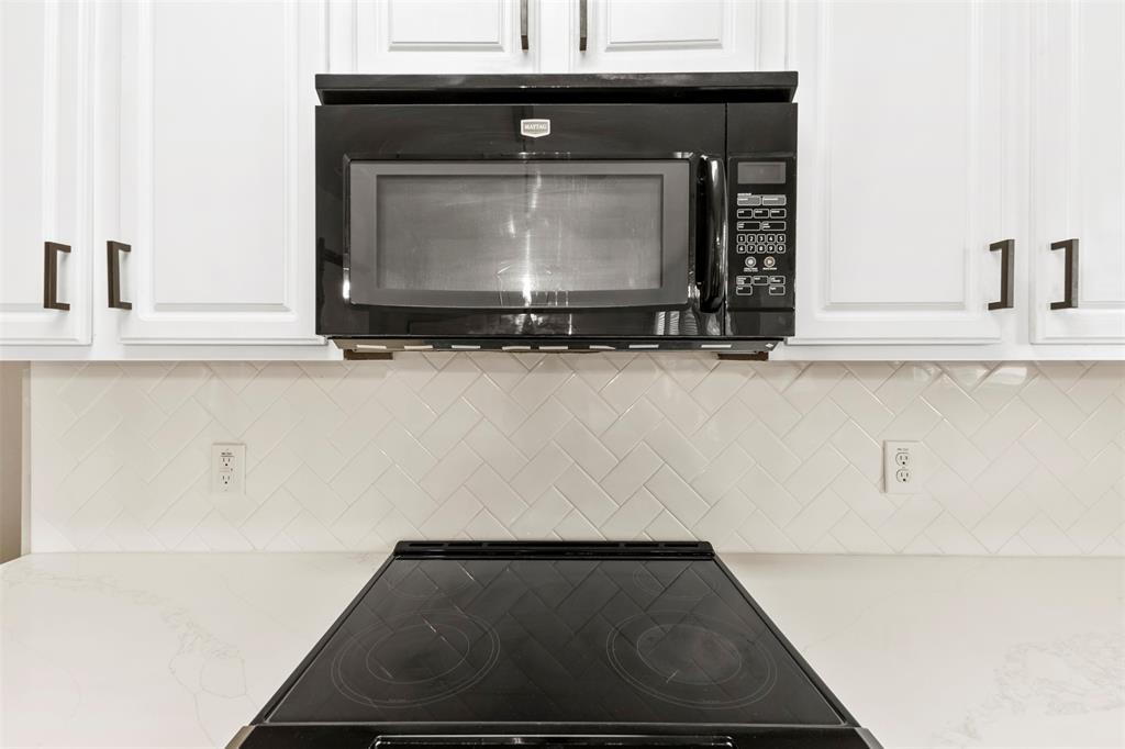 6522 Portside Ridge Lane Dallas, TX 75249 - Photo 11 of 37 Black over-the-range microwave paired with a black electric cooktop