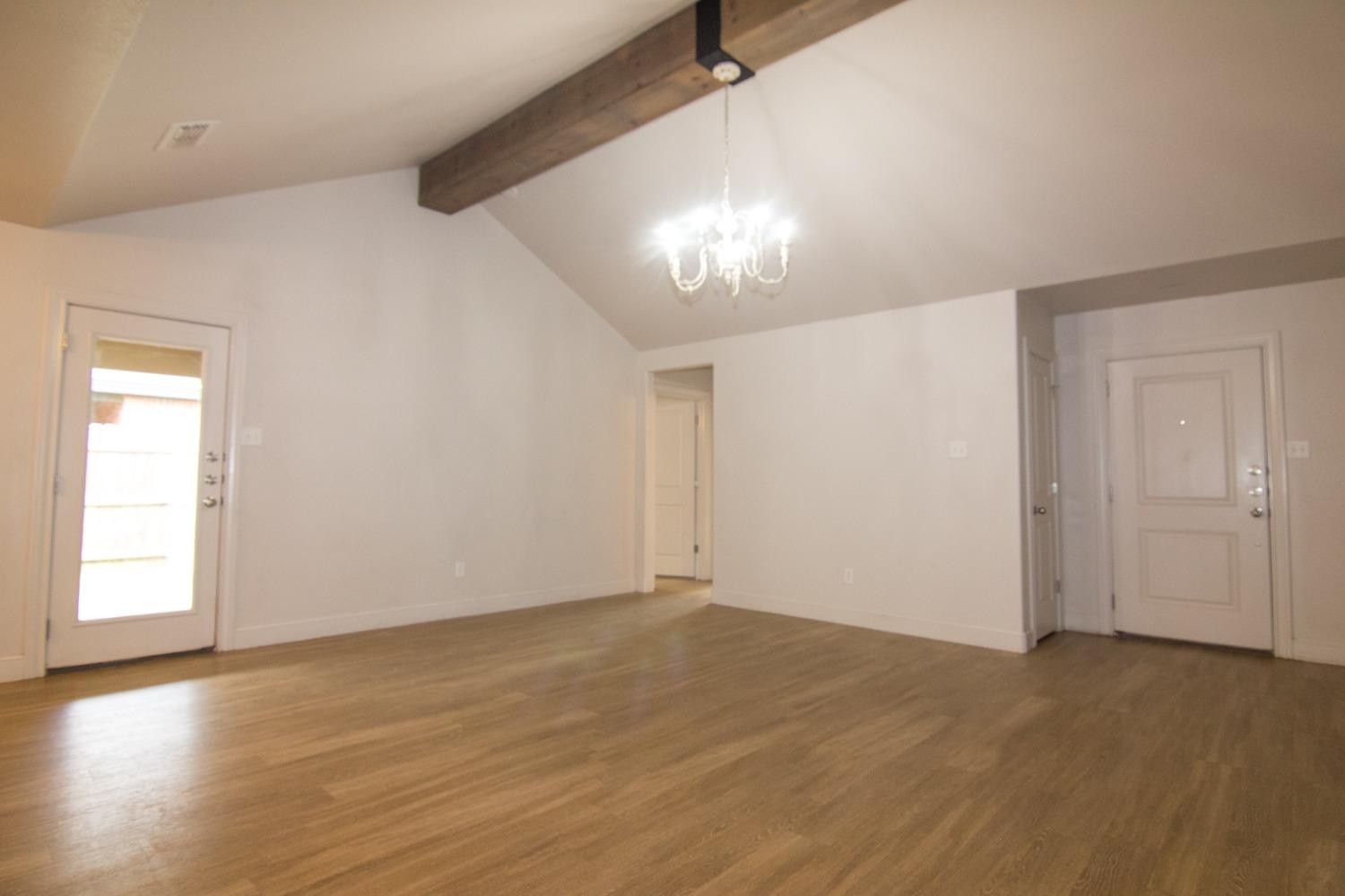 3821 133rd Street Lubbock, TX 79423 - Photo 2 of 15 wooden floor in an empty room with a window