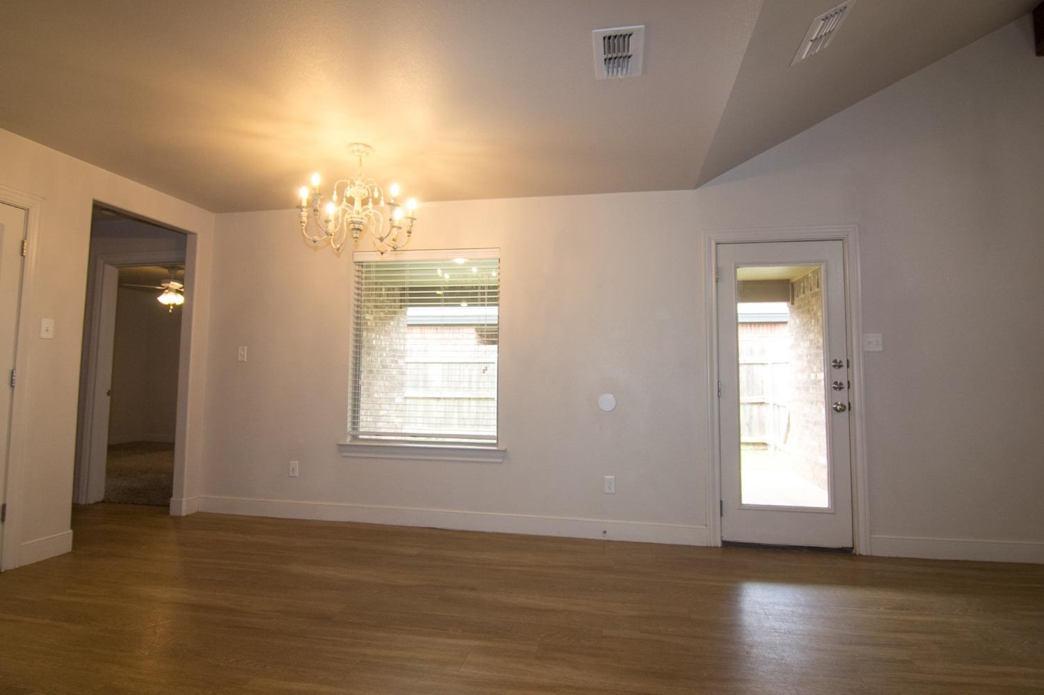 3821 133rd Street Lubbock, TX 79423 - Photo 4 of 15 a view of an empty room with wooden floor and a window
