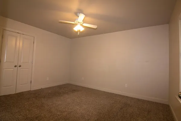 an empty room with a chandelier fan