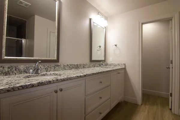 a bathroom with a granite countertop sink and a mirror