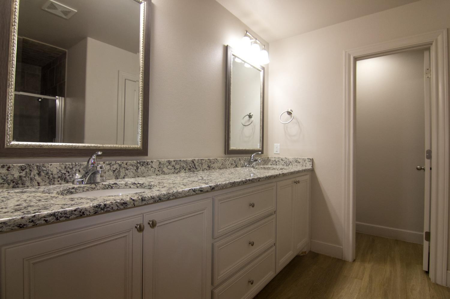 3821 133rd Street Lubbock, TX 79423 - Photo 6 of 15 a bathroom with a granite countertop sink and a mirror