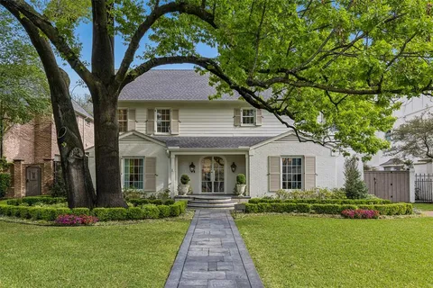 a front view of a house with a yard and potted plants