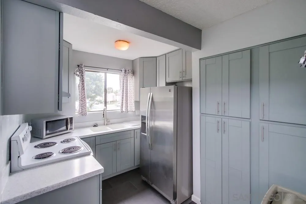 3583 Ruffin Road, Unit 209 San Diego, CA 92123 - Photo 33 of 39 a kitchen with stainless steel appliances a refrigerator sink and cabinets
