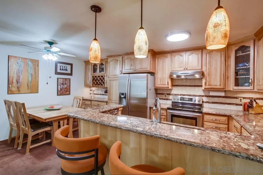 3583 Ruffin Road, Unit 209 San Diego, CA 92123 - Photo 8 of 39 a kitchen with kitchen island granite countertop a sink a stove and a dining table