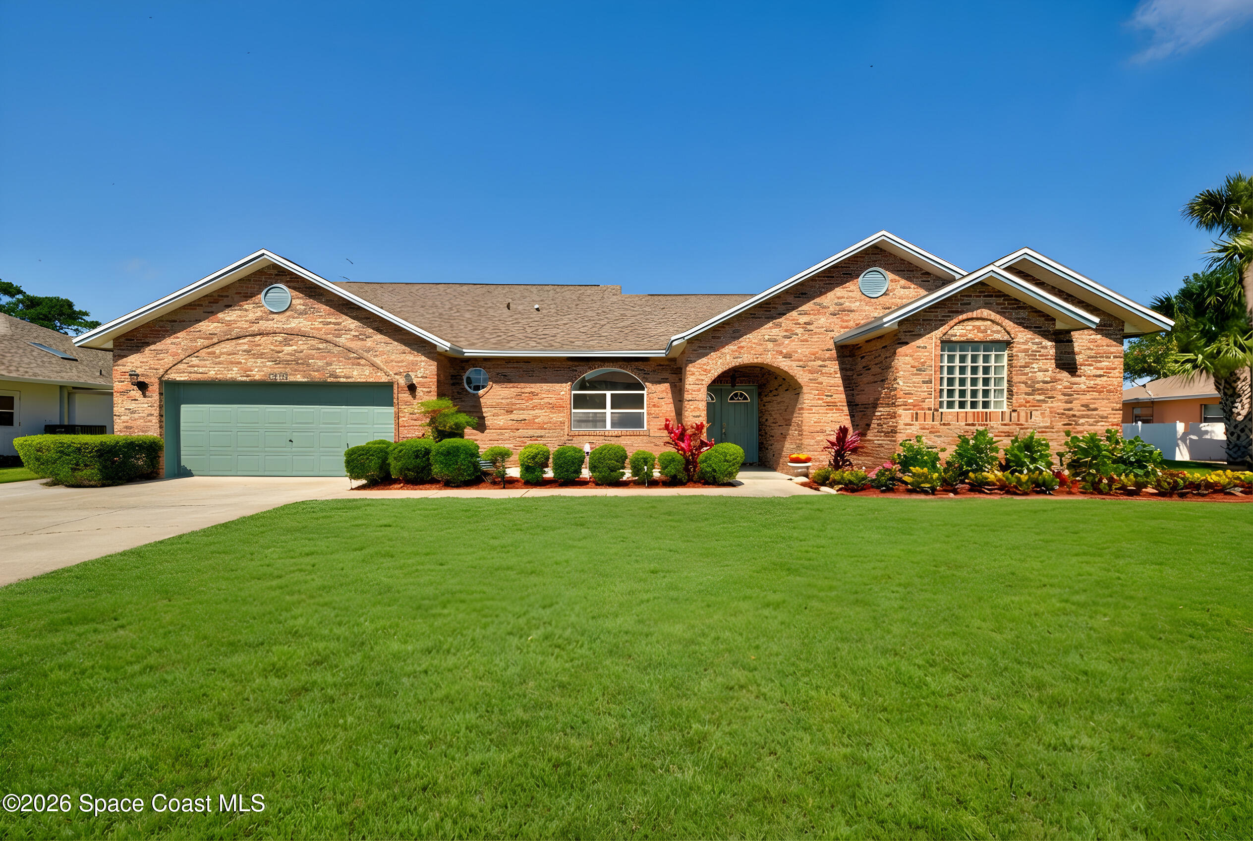 a front view of a house with a garden and yard