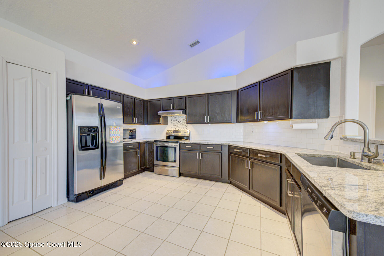 4065 Sand Ridge Drive Merritt Island, FL 32953 - Photo 15 of 59 a kitchen with stainless steel appliances granite countertop a sink refrigerator and cabinets