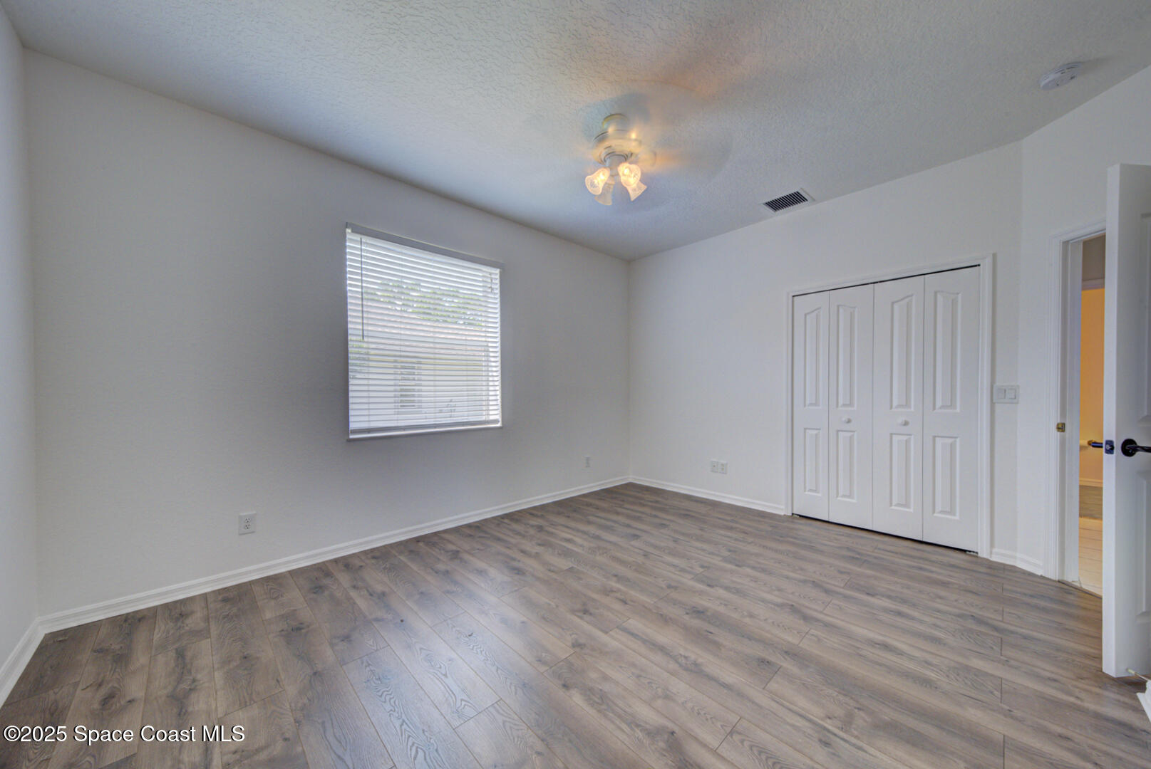 4065 Sand Ridge Drive Merritt Island, FL 32953 - Photo 30 of 59 a view of an empty room with wooden floor and a window