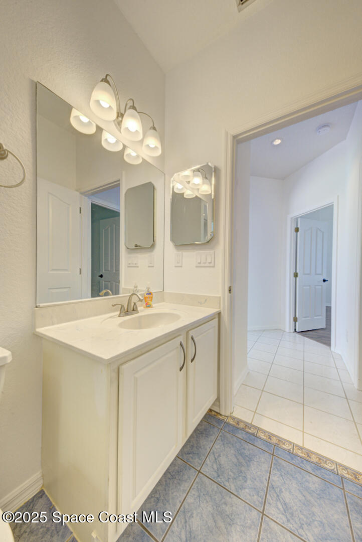 4065 Sand Ridge Drive Merritt Island, FL 32953 - Photo 32 of 59 a bathroom with a sink a mirror and a light fixture