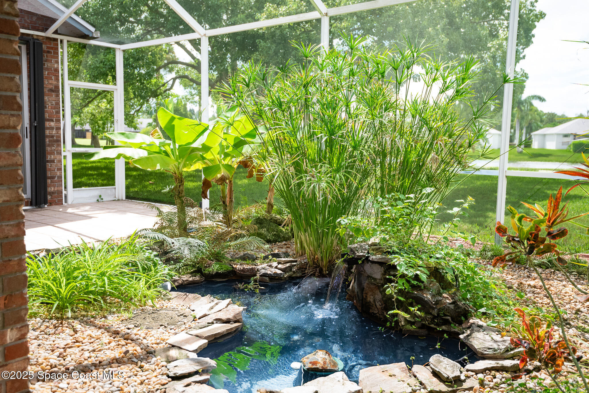 4065 Sand Ridge Drive Merritt Island, FL 32953 - Photo 36 of 59 a backyard of a house with lots of green space and a fountain