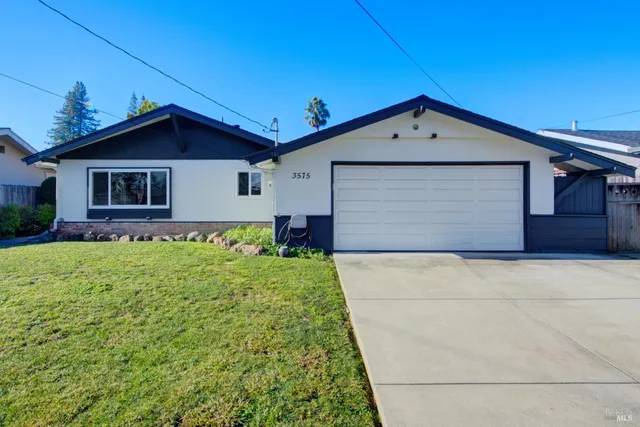 a view of a house with a yard and potted plants