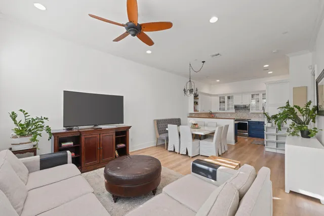 a living room with furniture a flat screen tv and a large window