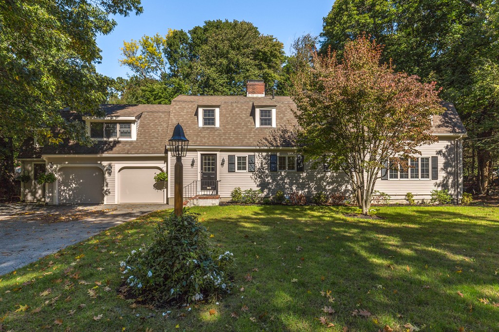 a view of a yard in front of a house with large trees