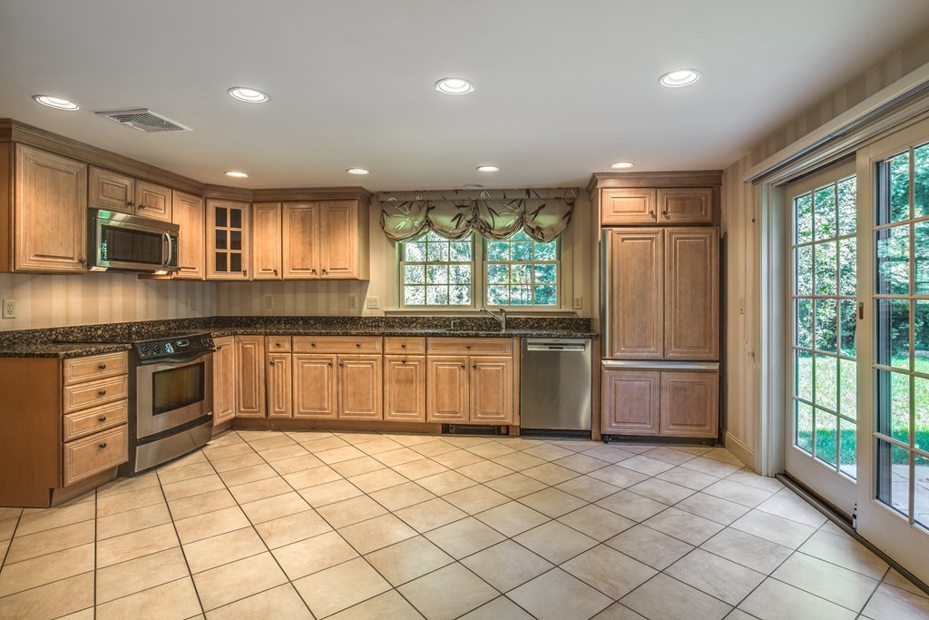 34 Leslie Road Winchester, MA 01890 - Photo 19 of 26 a kitchen with stainless steel appliances granite countertop a refrigerator a sink a stove top oven and a refrigerator