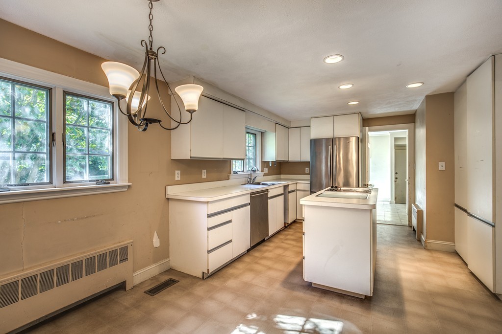 34 Leslie Road Winchester, MA 01890 - Photo 7 of 26 a kitchen with stainless steel appliances granite countertop a refrigerator a sink dishwasher a oven and a dining table with wooden floor