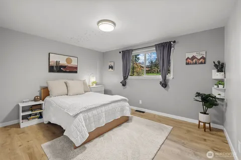 a bedroom with a bed and a painting on the wall