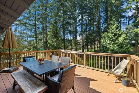 a balcony with wooden floor table and chairs