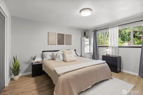 a bedroom with a bed and a large window