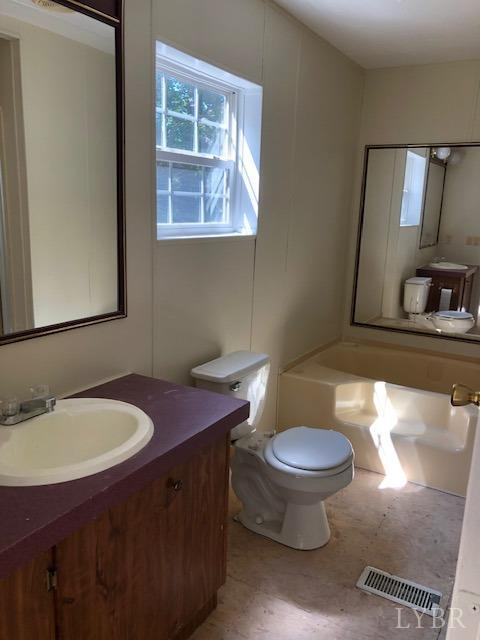 341 Broad Ridge Road Sandy Level, VA 24161 - Photo 14 of 16 a bathroom with a toilet sink and mirror