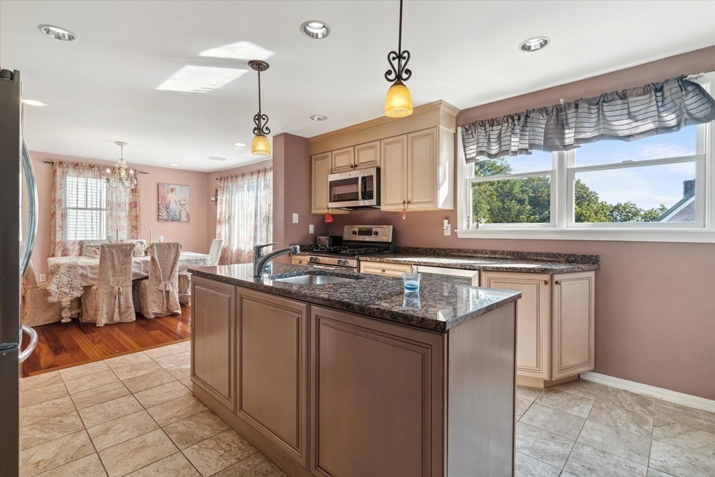 49 Dibble Road Lynn, MA 01904 - Photo 9 of 41 a kitchen with stainless steel appliances granite countertop a stove a sink dishwasher and a microwave oven with cabinets