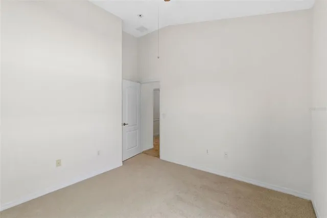 an empty room with a window and a ceiling fan