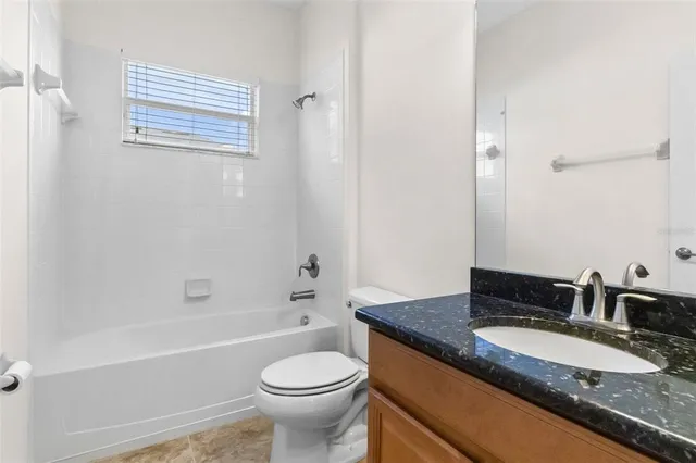 an empty room with chandelier fan and windows