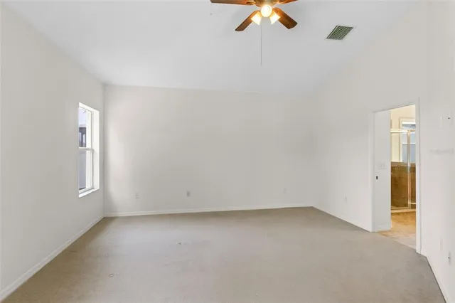 an empty room with closet and a chandelier fan