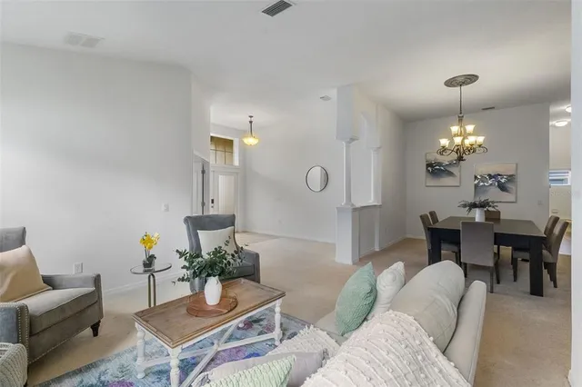 a living room with furniture flowers and a chandelier