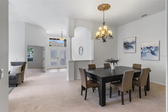 a view of a dining room with furniture and chandelier