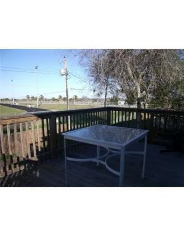 a view of a balcony with furniture and wooden floor