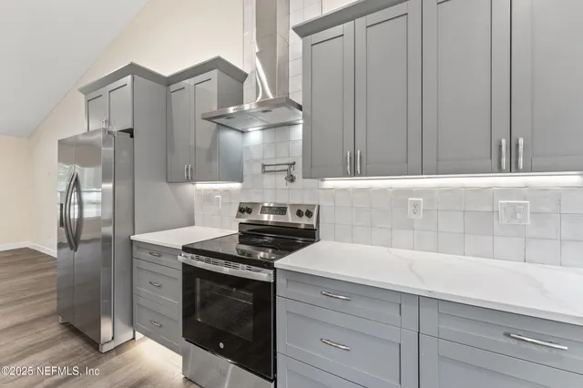 a kitchen with granite countertop a stove and a white cabinets