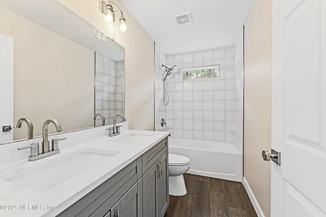 a bathroom with a bathtub shower sink mirror and toilet