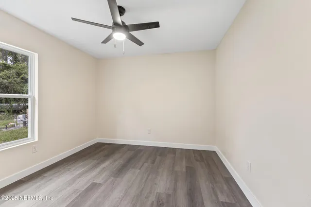a view of a room with wooden floor and a window