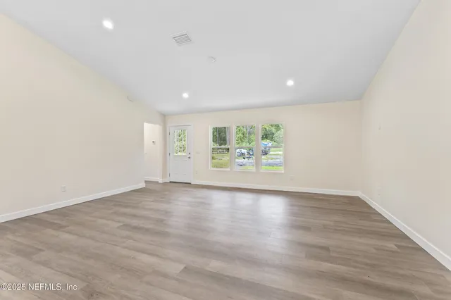 an empty room with window and wooden floor